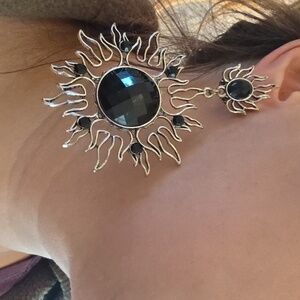 Gothic or celestial-style dangle earrings featuring a sun motif